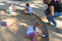Dzieci szukają w piaskownicy skamieniałości