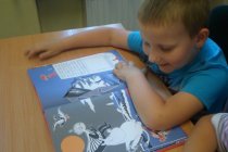 Chłopiec czytający książkę o Muminkach