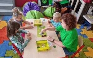 Bibliotekarka z dziećmi gra w planszówkę