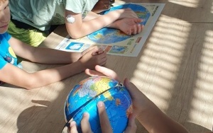 Dzieci szukają na mapie i globusie Ameryki Północnej i Południowej