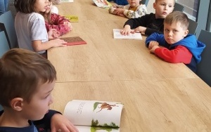 Przedszkolaki oglądające książeczki z wierszami Jana Brzechwy