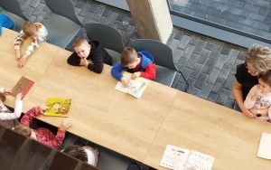 Przedszkolaki oglądające książeczki z wierszami Jana Brzechwy