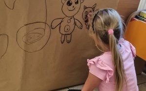 Dziecko wykonuje rysunek na ścianie jaskini.