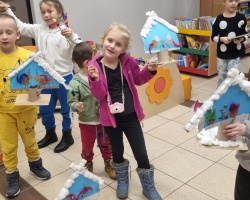 Dzieci chwalą się papierowymi karmnikami dla ptaków