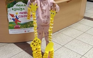 Dziewczynka prezentuje papierową żyrafę