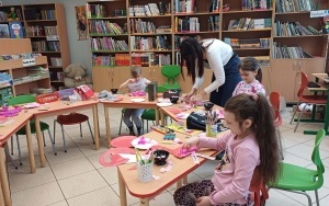 Uczestnicy wykonują flamingi z papieru i piór