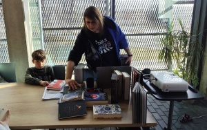 Bibliotekarka prezentuje książki o twórczości braci Grimm i różne wydania baśni